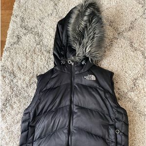 The North Face Puffy Winter Vest Size L with removable fur hood. Preowned.